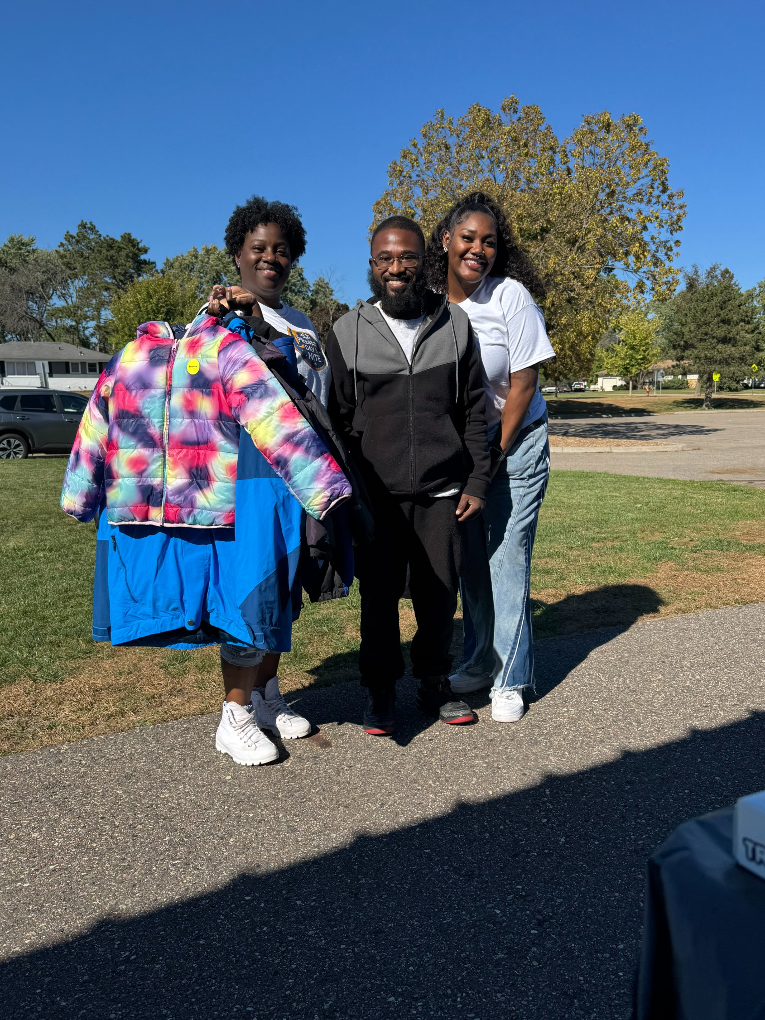 Prevail volunteers and a community member with coats at an outreach event