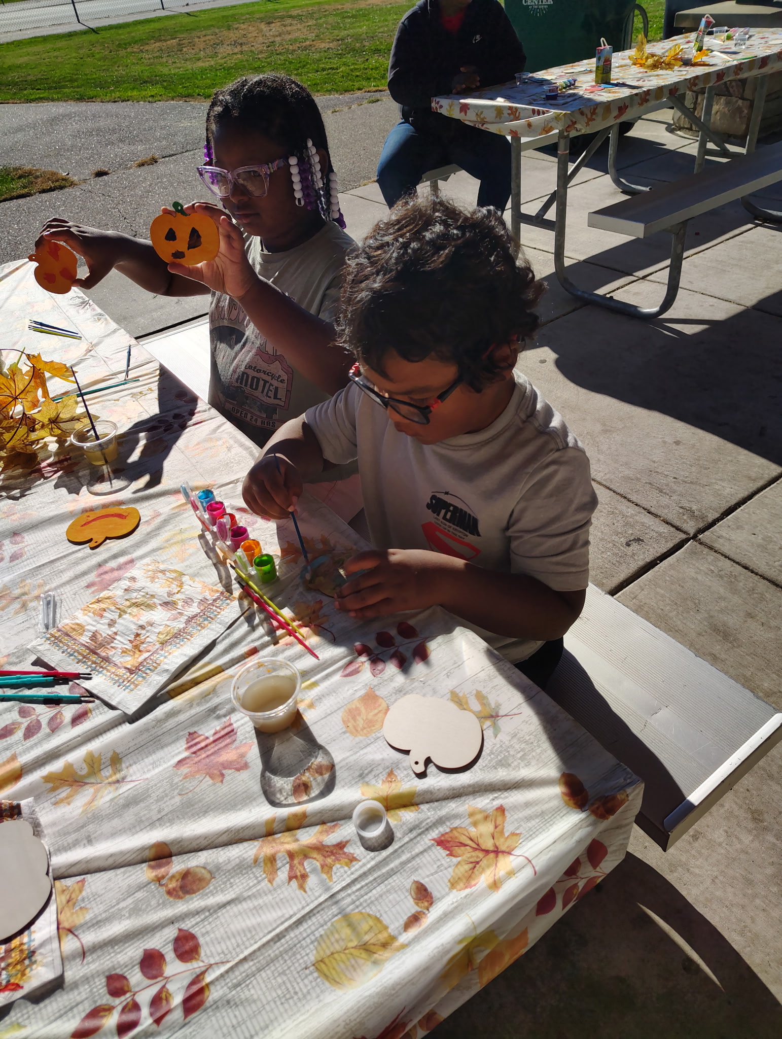 Children painting pumpkins at a community fall event